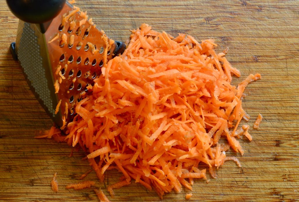 shredded carrot next to a grater