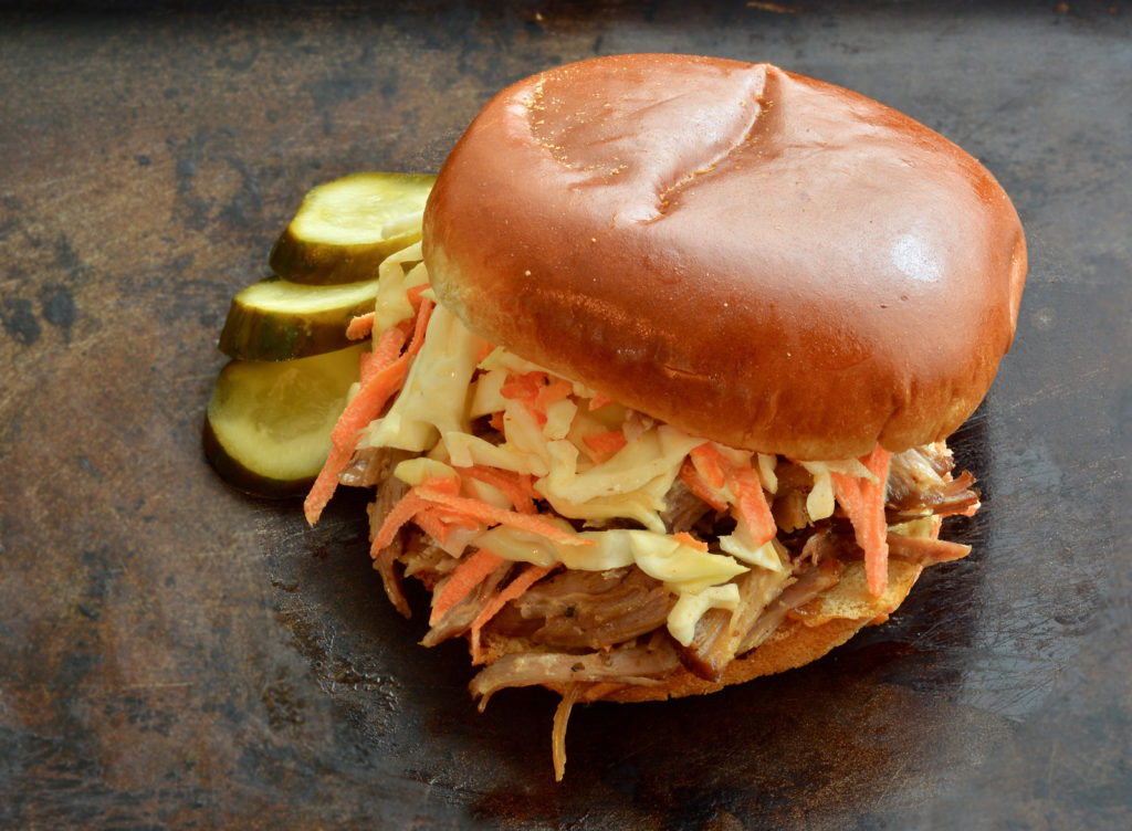 Pulled Pork Sandwich with Coleslaw and a side of pickles 